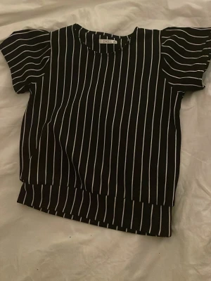 Svartvit randig blus från D-XEL - Säljer en svart blus med vita ränder från D-XEL i storlek 152 men funkar som xs eller s. Toppen är väl använd men fortfarande i gott skick. Jag säljer för den är nu för liten för mig och inte min stil💓