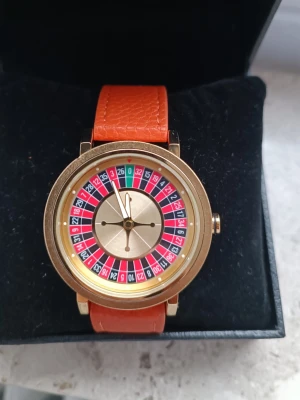 Roulette-klocka i Guld & Orange – Las Vegas på handleden! 🎰🎲 - Ja den snurrar.                                                      Säljer en riktigt cool och annorlunda klocka med kasinotema! 