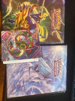 Ingen väst på bilderna - Pokemon pärmar inkluderad med ett stort Pokémon V kort  