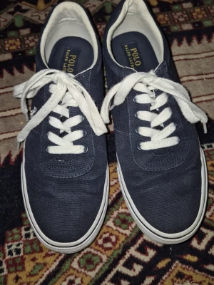 Ralph Lauren skor! - Superfina Ralph Lauren skor. Köpta här på Plick i höstas, mycket använda men I gott skick! Lite smutsiga och repiga på det vita, skosnörena och insidan men fint skick. Storlek 39 men passar bra på mig som vanligtvis har mindre.