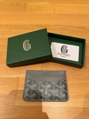 Korthållare - Snygg korthållare i grått skinn med klassiskt mönster och gul insida. Perfekt för kort och cash, med flera fack och stilren design. Kommer med original ask och kort.