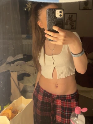 Vit croppad topp från Only Trend - Superfin vit croppad topp från Only Trend i ribbad bomull. Modellen har korta ärmar, knappar framtill och en snygg v-ringning. Perfekt till jeans eller kjol för en chill look.