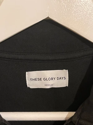 These Glory Days Overshirt svart  - Säljer denna sjukt snygga Overshirten från These Glory Days⭐️ Färgen är svart och storleken är M✅ Den har inga defekter och skicket är utomordentligt🙌🤝 Sjukt najs passform och passar perfekt till hösten🍁🙌 Tveka inte på att höra av er dig vid minsta fråga eller fundering😊