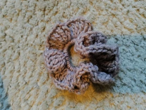 Glittrig handgjord scrunchie I rosa och grått - Snyggt handgjord virkad scrunchie i grå och rosa med glittriga inslag som ger extra shimmer. Perfekt för att piffa upp din frisyr och ge en unik touch till din look. Mjukt och bekvämt material som sitter skönt hela dagen. Virkad av mig!