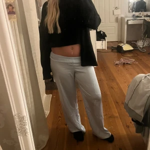 Ljusblå vida mjukisbyxor - Säljer ett par ljusblå mjukisbyxor med resår i midjan och avslappnad passform. Byxorna har raka, vida ben och är tillverkade i ett mjukt material som känns skönt mot huden. Perfekta för en chill dag hemma eller när du vill vara bekväm men ändå se snygg ut.