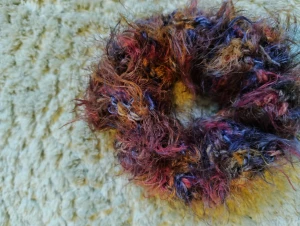 Färgglad fluffig scrunchie  - Unik och fluffig handgjord scrunchie i flera färger som lila, röd, blå och brun. Den har en mjuk och lurvig textur som ger en cool och lekfull vibe till din frisyr. Perfekt för att sätta färg på din look och hålla håret på plats. Virkad av mig om någon undrar!🙃🤗