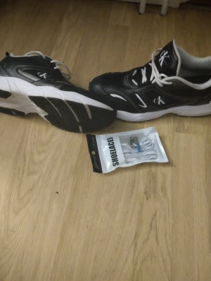  Calvin Klein sneakers bra skick 42/43 med nya snören på köpet. - Snygga chunky sneakers från Calvin Klein Jeans i svart och vitt med tydlig CK-logga på sidan, plösen och innersulan. Skorna har vit platt sula, rund tå och vita snören. Materialet är en mix av syntet och skinn för en modern look. Perfekt för dig som gillar streetstyle. Stl 42 men passar även 43 , använd enstaka gr. Bra skick.  Nypris 1499kr.