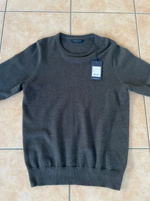 Mörkgrå crew neck tröja Berkeley S - Snygg mörkgrå crew neck tröja från Berkeley i storlek S. Tillverkad i 100% bomull med ribbade muddar vid hals, ärmslut och nederkant. Helt o använd. Lappen kvar. 