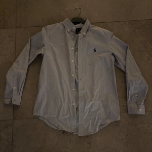  Ralph Lauren skjorta  - Klassisk ljusblå skjorta från Ralph Lauren med button-down krage och broderad logga på bröstet. Bra passform och är tillverkad i mjuk bomull. Knappt använd, Size S, skick 8,5/10