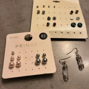 Stort örhängeskit  - Säljer ett stort kit med örhängen, totalt över 20 par i olika stilar och färger. Här finns pärlörhängen i vitt och silver, glittriga blå studs, metallicfärgade bollar, röda och blå studs samt hängande örhängen med transparenta detaljer. Perfekt för dig som gillar att variera din look.