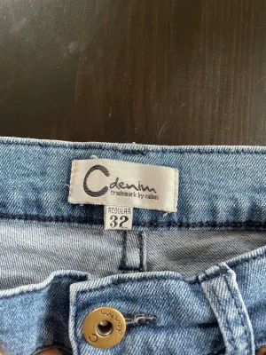 Blå jeans från Cubus denim, regular 32 - Säljer ett par klassiska ljusblå jeans från Cubus denim i regular fit, storlek 32. Modellen har rak passform, fem fickor och knappstängning framtill. Lite stretch. Perfekt för dig som gillar enkel och tidlös stil.