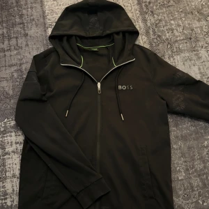 BOSS Hoodie (äkta) - Stilren svart BOSS-hoodie i storlek M. Äkta och i riktigt fint skick, endast använd två gånger. Nypris runt 2800 kr. Perfekt plagg som lyfter vilken outfit som helst. Skickas direkt. Pris kan alltid diskuteras😁
