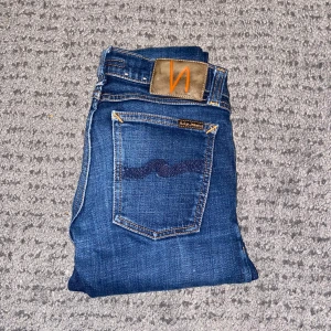 Nudie jeans - Snygga blå jeans från Nudie Jeans. Midja - 31cm, Längd - 91cm. Jeansen är skinny och är i bra skick. Tveka inte på att fråga mig saker!