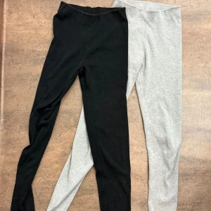 Svarta och grå leggings i bomull - Två par leggings i mjuk bomull, ett par svarta och ett par grå. De har en enkel, tight passform och hög midja som sitter skönt. Perfekta att matcha med hoodies eller t-shirts för en chill look. Storlek S💕