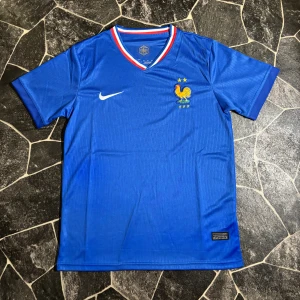  Frankrike fotbollströja Nike - Säljer en blå Frankrike fotbollströja från Nike med FFF-logga och två stjärnor på bröstet. Tröjan har korta ärmar, V-ringad krage med röd, vit och blå kant. Materialet är lätt och andas, perfekt för match eller träning.