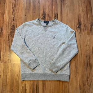 Grå Ralph lauren tjocktröja size S/170  - Äkta grå Ralph lauren tröja 🐎Tröjan mäter 60 cm i längd, 47 cm i bredd, 54 cm i ärmlängd. Den är i jättefint skick och har inga skador eller defekter. 