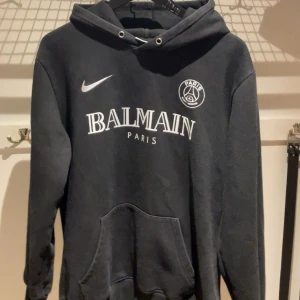 Svart Balmain x PSG hoodie - Svart hoodie från Balmain x PSG med vit logga och tryck på bröstet. ⚽️