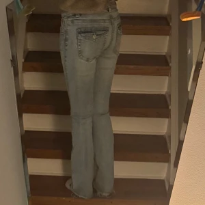 Ljusblå bootcut jeans med fickdetalj - Snygga ljusblå jeans med bootcut passform och klassiska fem fickor. Fransiga längst ner i benen. 