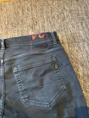 Dondup George - Snygga mörkgrå jeans från Dondup. Klassisk femficksmodell. Har en diskret D-detalj på bakfickan. Perfekt för dig som gillar stilrena och coola jeans.