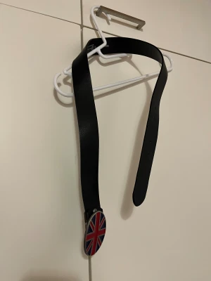 Vyö 85 - Musta 85cm pitkä vyö. Lukossa iso britannian lippu. Nikkeli vapaa. Eläintalous MMM, lisätietoja saa kysymällä Katsothan myös muut ilmoitukseni Tarjoa 