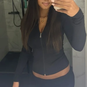 Svart zip-tröja Nelly - Säljer en svart, slim kofta med dragkedja framtill. Från Nelly, använd fåtal gånger.