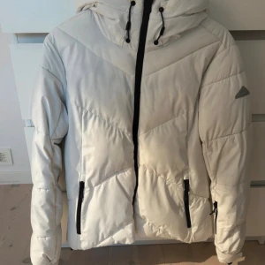 Vit skidjacka McKinley - Superfin vit jacka perfekt för skidåkning! Storlek 38 men skulle säga att den även passar 36. Bra skick utöver de fläckar som finns på kragen men skulle tro att de går bort i tvätt. 
