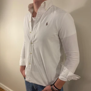 Vit Ralph Lauren skjorta - Nu säljer vi ännu en snygg polo skjorta som passar till alla tillställningar! Du ska kunna uttrycka stil utan att det kostar för mycket!🕺🍾💼🤩  Storlek👔: S Nypris💰: ca 1399kr