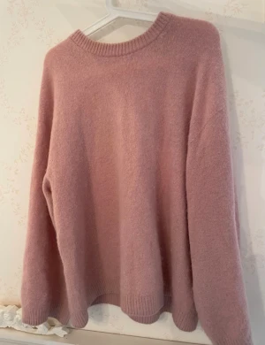 Ljusrosa stickad tröja ARKET - Mysig ljusrosa stickad tröja med rund hals och ribbade muddar vid ärmslut och nederkant. Från ARKET, nypris 999 kr