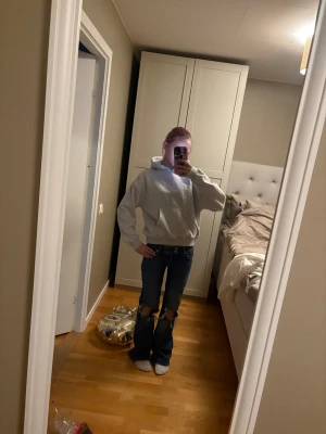 Ljusgrå hoodie med huva - Enkel och stilren ljusgrå hoodie med huva och magficka. Tröjan har en loose passform och ribbade muddar vid ärmslut och nederkant. Perfekt för chill dagar och passar till allt. Materialet känns mjukt och skönt mot huden.