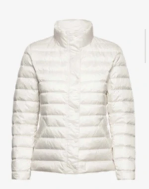 Gant jacka  - Säljer en fräsch vit dunjacka med hög krage och horisontella quiltade paneler. Jackan har lång ärm och stängs med dragkedja framtill. Perfekt för kyliga dagar när du vill hålla värmen och ändå se clean ut. Nytt pris: 2 500 kr. Har använts en gång. Den är nytvättad och redo för en ny ägare.  Kan fraktas. (Köparen står för frakt)   Skriv gärna om ni har mer frågor. 