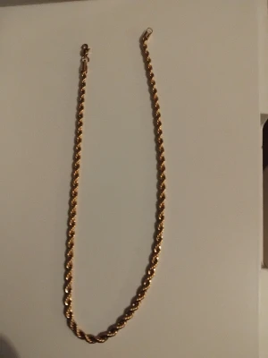 Guldfärgad tvinnad kedja - Snygg guldfärgad kedja med tvinnad design som ger ett coolt och stilrent intryck. Perfekt att bära som halsband eller armband. Metallmaterial och klassisk låsanordning. Passar dig som gillar att sticka ut med accessoarer. Äkta 18k guld