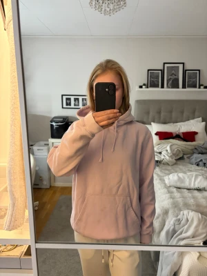 Ljuslila/rosa  hoodie med huva - Säljer en ljuslila/rosa hoodie med stor huva. Små fleckar vid magfickan men syns knappast och lär gå ut i tvätt med t.ex galltvål. 