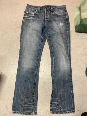 Hysteric glamour - Ser ut som hysterisk jeans i klassisk blå tvätt med slitningar och detaljerade bakfickor. Bootcut-modell med normal passform och låg midja. Jeansen har slitna partier och fransade detaljer framtill, tillverkade i robust denim. Jag är 180 i bilderna 