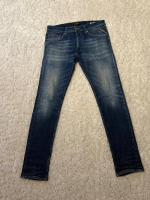 Replay Anbass skinny jeans blå - Snygga Replay Anbass jeans i mörkblå tvätt med slitningar och skinny passform. Klassisk femficksmodell med dragkedja och knapp, samt Replay-logga på bakfickan. Jeansen är tillverkade i stretchigt denim för extra komfort.