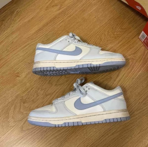 Blåa dunks  - Wmn dunk low next nature i storlek 37.5 super super fin sko för varma dagar och är i väldigt fint skick, endast använts ett antal gånger (därav bild 3) men har verkligen används med omsorg. Hör av er!