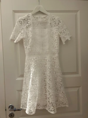 Vit spetsklänning från Bubbleroom - Säljer min studentklänning. Superfin vit kortklänning från Bubbleroom med blommigt spetsmönster och korta ärmar. Klänningen har rund halsringning, markerad midja och vackra spetsdetaljer över hela plagget. Endast använd en gång. Mycket bra skick. Storlek 34💕