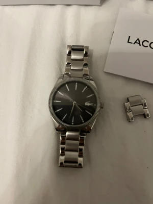 Lacoste klocka  - Väldigt fin klocka, färgen har inte gott bort och kommer aldrig heller och den är inte heller skadat. Känns som ny. En klassisk klocka funkar me män och kvinnor också. Kommer med extra band och jag lägger in ett klocka fixare