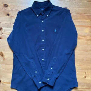 Polo Ralph Lauren Skjorta - Säljer min Ralph Lauren-skjorta – Strl S 🙌🏼 Riktigt snygg mörkblå skjorta från Ralph Lauren med ljusblå brodyr 💙 Slim fit som sitter perfekt & ger en stilren look 👌🏼    ✅ Storlek: S 👕  ✅ Bekväm & klassisk 🙌🏼  ✅ Mycket bra skick 🌟    Perfekt både till vardag & fest 🎉    Tveka inte på att höra av er!