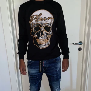 Philipp Plein tröja strl S - Helt ny.fin replika med grym kvalitet. Modellen är 175cm väger 67 kg, Bär S på bilden. Pris: 899kr. Först till kvarn som gäller. Skickas direkt inom 24h
