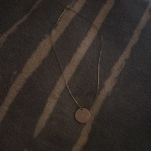 Silverhalsband med stjärnteckenberlock - Snyggt halsband i guld med en tunn kedja och en rund berlock. Berlocken har ett ingraverat stjärntecken med små gnistrande stenar som markerar stjärnorna. Perfekt för dig som gillar astrologi och vill ha något personligt.