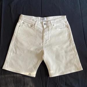 Vita jeansshorts från Jack & Jones - Snygga vita jeansshorts från Jack & Jones med klassisk femficksdesign och knappgylf. Shortsen har en rak passform och är perfekta för varma dagar. Tillverkade i kraftig bomull med minimalistisk look och diskreta detaljer.