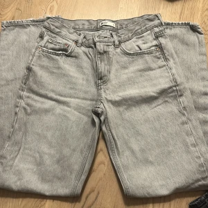 Gina low waist  jeans straight fit - Säljer ett par klassiska Levis 501 jeans i ljusgrå tvätt. Byxorna har raka ben, fem fickor och knappgylf. Perfekta för dig som gillar en tidlös och avslappnad stil. Materialet är robust denim i bomull.