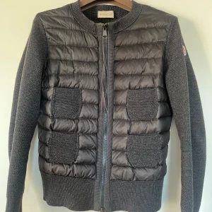Moncler cardigan - Säljer nu min klassiska mörkgrå moncler cardigan med fyra fickor och dubbel dragkedja. Storlek XS dam. Den är använd men i fint skick. Pris kan diskuteras. Skriv för fler bilder eller frågor!🩷