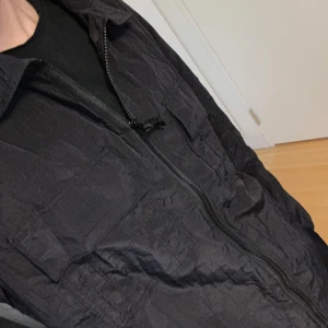 Svart overshirt från Stone Island - Säljer en svart overshirt från Stone Island med klassisk patch på ärmen. Jackans material är tunt, passar perfekt nu till hösten. Skriv vid minsta fundering.