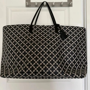 By Malene Birger shoppingväska | Tote bag Large  - Size - Large  (Den största modellen)! Väskan är i toppen skick endast använt 2 gånger. Stor och rymlig shoppingväska från By Malene Birger i svart och vitt med grafiskt rutigt mönster. Väskan har svarta handtag, innerfoder i ljusrosa och en praktisk innerficka med dragkedja.  B.36cm H.65cm D.36cm Material - leather.  Inga defekter,  är i nyskick!