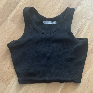 Svart ribbad croppad linnetopp XS - Säljer en svart croppad linnetopp från lager 157 i storlek XS. Toppen är ribbad och har breda axelband samt rundad halsringning. Perfekt för en chill och stilren look, lätt att matcha med jeans eller kjol.