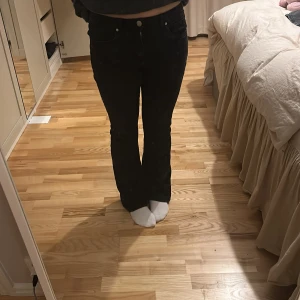 Svarta bootcut jeans - Snygga svarta jeans med bootcut-modell och klassisk femficksdesign. Byxorna har en figurnära passform upptill och lätt utsvängda ben. Perfekta för dig som gillar en tidlös och stilren look.