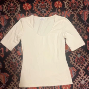 Beige topp med rund hals - En stilren beige topp från lindex med rund halsringning och halvlånga ärmar. Perfekt för att matcha med jeans eller kjol för en enkel och clean look.