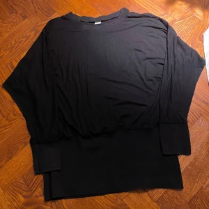 Mamma tröja Polarn O. Pyret - Svart långärmad tröja från Polarn O. Pyret i storlek L. Tröjan har breda muddar vid ärmslut och midja, rund halsringning och är tillverkad i mjuk bomull. Enkel och clean stil som passar till allt.