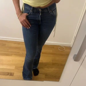 Gina blå bootcut jeans - Snygga blå jeans från Levi's med klassisk bootcut-passform och hög midja. Jeansen har fem fickor, dragkedja och knapp framtill samt Levi's ikoniska läderpatch bak. Tillverkade i slitstarkt denim som sitter riktigt bra och ger en schysst siluett.